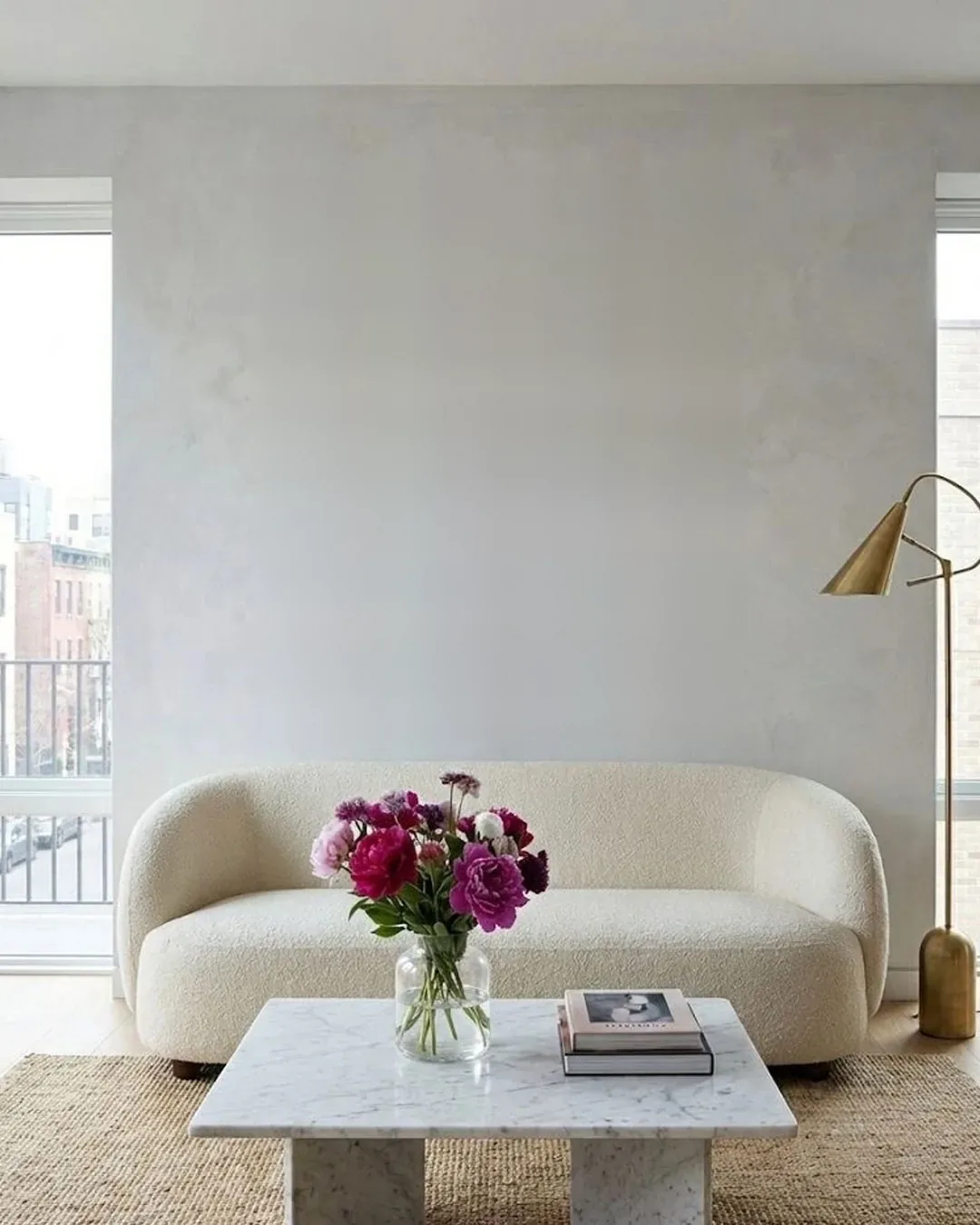 A living room with a cream sofa and a blank wall